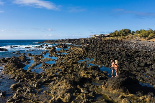 The couple stands on Rough rock formations near the ocean on the island of Tenerife.The Canary Islands.Tenerife.Spain.