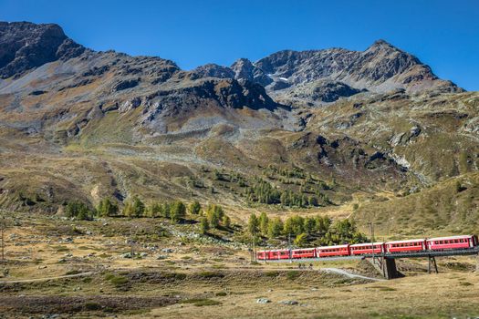 Swiss train in the alps mountains around Bernina pass, Engadine valley, Switzerland