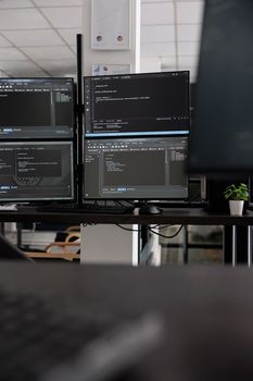 Computer screens showing compiling html code in empty developing office, security system parsing data algorithms in background. Artificial intelligence servers cloud computing in big data agency.