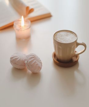 coffee cup, cotton flower, open book on a white table background top view. minimal home interior decor. 