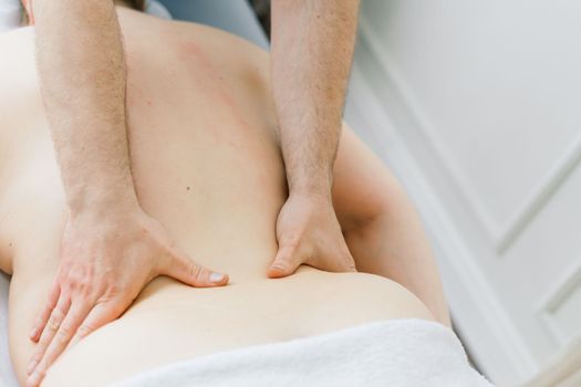 Young fat woman getting massage treatment in a day spa cabinet.