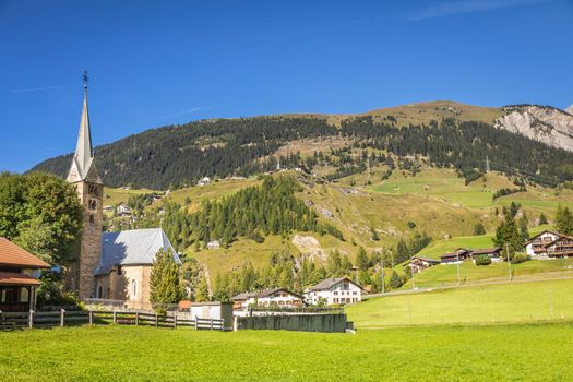 Idyllic landscape of church in Engadine valley at sunny springtime, Swiss Alps, Switzerland