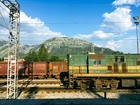 View of a rail yard with mountains in the background and overhead power lines in budvha dubrovnik. High quality photo