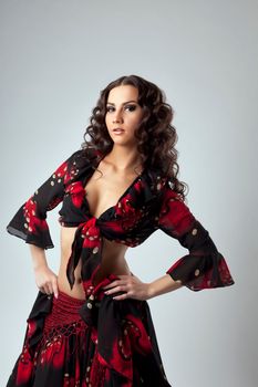 Cute young dancer stand in gypsy costume on grey