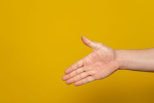 Man stretching out his hand to handshake isolated on an orange background. Man's hand ready for handshake. Alpha.