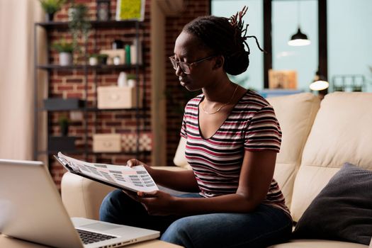 Freelance worker analyzing report, holding clipboard with papers, working in home office. Serious freelancer reading research, looking at data, thoughtful remote employee