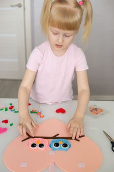 A blogger girl makes a felt craft for Valentine's Day in the shape of a heart. The concept of children's creativity and handmade