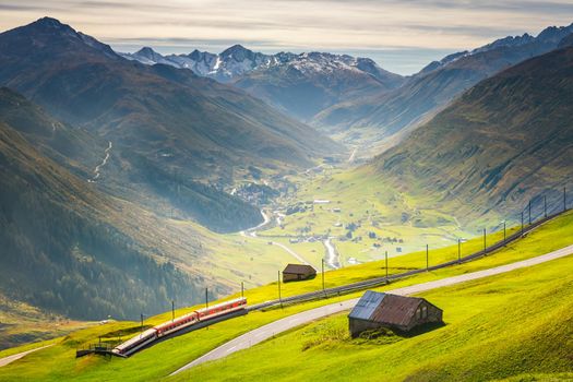 Swiss train in the alps mountains around Andermatt Urseren valley, Uri, Switzerland