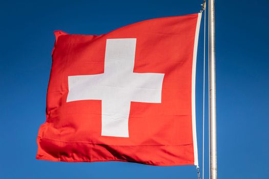 Switzerland flag with blue sky in the background