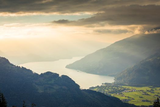 Aerial view of Swiss Alps and Lake Thun at dramatic sunset, Interlaken, Switzerland