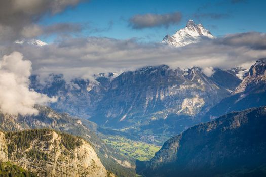 Misty Eiger above Grindelwald valley, Snowcapped Bernese Swiss alps at sunset, Switzerland
