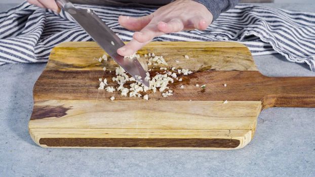 Cutting organic garlic on a wood cutting board.