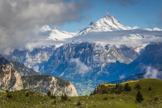 Misty Mountain above Grindelwald valley, Snowcapped Bernese Swiss alps at sunset, Switzerland