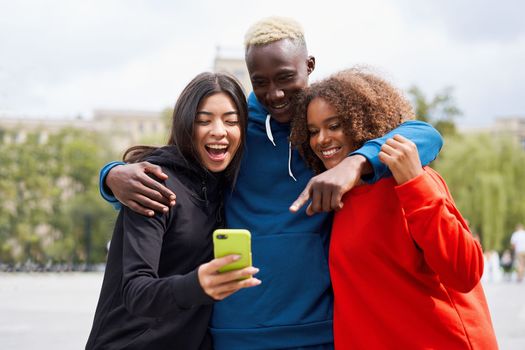 Multi ethnic friends outdoor looking smartphone screen. Diverse group people Afro american asian spending time together Multiracial male female student meeting outdoors
