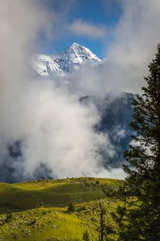 Misty Mountain above Grindelwald valley, Snowcapped Bernese Swiss alps at sunset, Switzerland