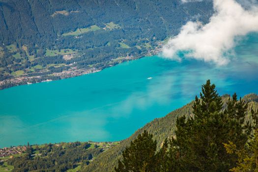 Aerial view of Swiss Alps and Lake Brienz with ferry boat at dramatic sunset, Interlaken, Switzerland
