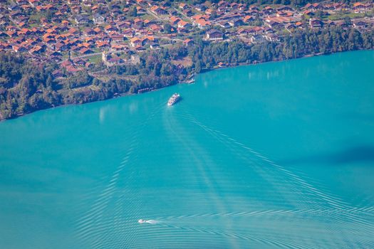 Aerial view of Swiss Alps and Lake Brienz with ferry boat at dramatic sunset, Interlaken, Switzerland