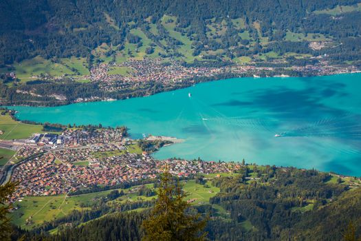 Aerial view of Swiss Alps and Lake Brienz with ferry boat at dramatic sunset, Interlaken, Switzerland