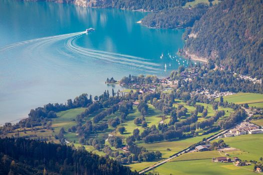 Aerial view of Swiss Alps and Lake Thun with ferry boat at dramatic sunset, Interlaken, Switzerland