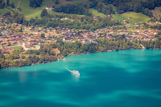 Aerial view of Swiss Alps and Lake Brienz with ferry boat at dramatic sunset, Interlaken, Switzerland