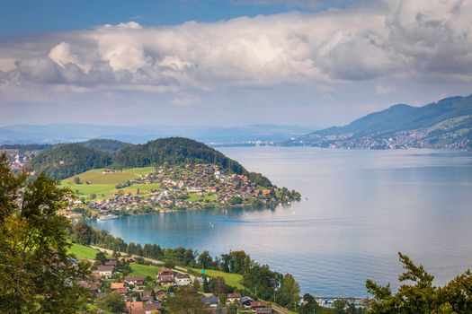 Aerial view of Swiss Alps and Lake Thun with ferry boat at dramatic sunset, Interlaken, Switzerland
