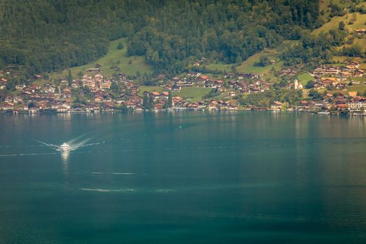 Aerial view of Swiss Alps and Lake Thun with ferry boat at dramatic sunset, Interlaken, Switzerland