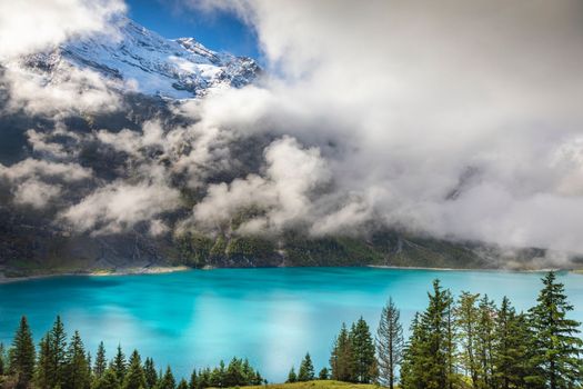 Misty Oeschinensee, Oeschinen lake, on Bernese Oberland swiss alps, Kandersteg, Switzerland