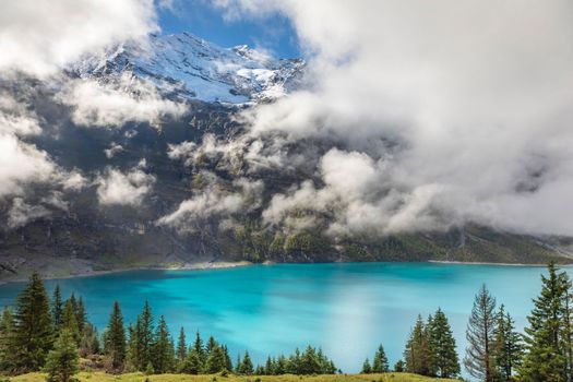 Misty Oeschinensee, Oeschinen lake, on Bernese Oberland swiss alps, Kandersteg, Switzerland