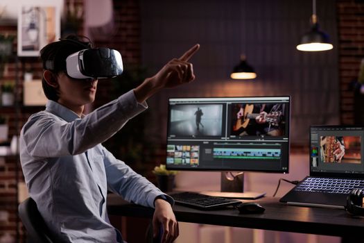 Male editor working on media production with vr headset and creative software, editing movie footage or film montage on computer. Creating video edit with audio and visual effects on monitor.