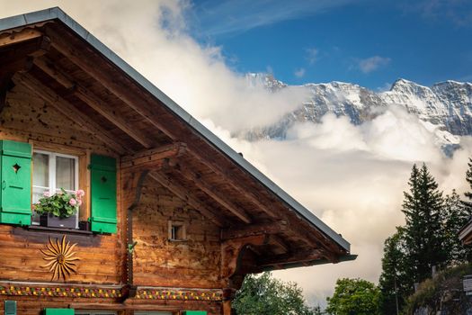 Colorful flowers in rustic chalet at springtime with mountains, Interlaken, Swiss alps