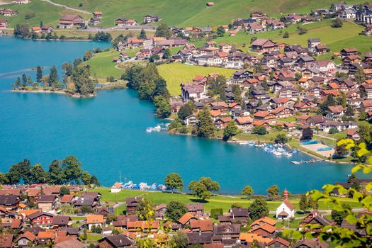 Turquoise Lungernsee and village lungern in the Swiss Alps at sunny day, Switzerland