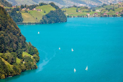 Turquoise Lungernsee and village lungern in the Swiss Alps at sunny day, Switzerland