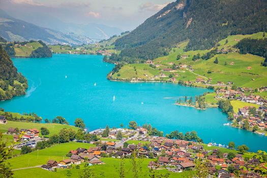 Turquoise Lungernsee and village lungern in the Swiss Alps at sunny day, Switzerland