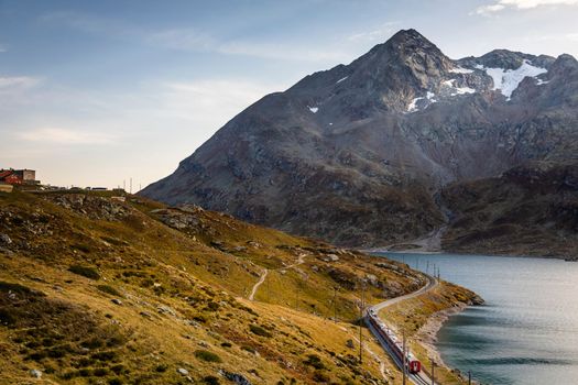 Swiss train in the alps and lake around Bernina pass, Engadine valley, Switzerland