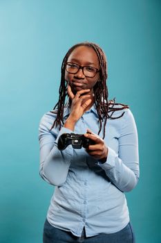 Sad adult gamer with videogame console modern controller losing online competitive match. African american woman getting upset because of lost game played on entertainment electronic device.