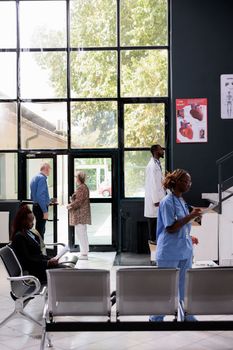 People standing in hospital waiting area during checkup visit appointment, medical staff preparing to start medical consultation with sick patients. Health care service and concept