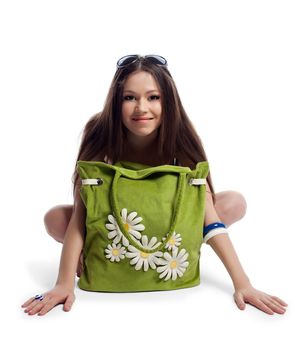 Yong woman sit with green beach bag with camomile flowers isolated