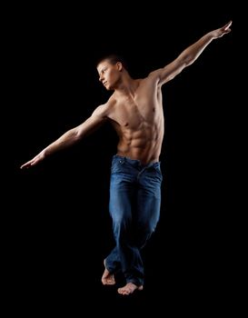 youn strong man with naked torso in jeans posing in dark