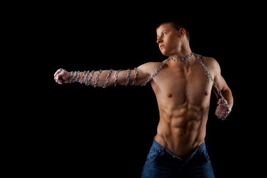 aggressive athletic man with chain on hands fight on light