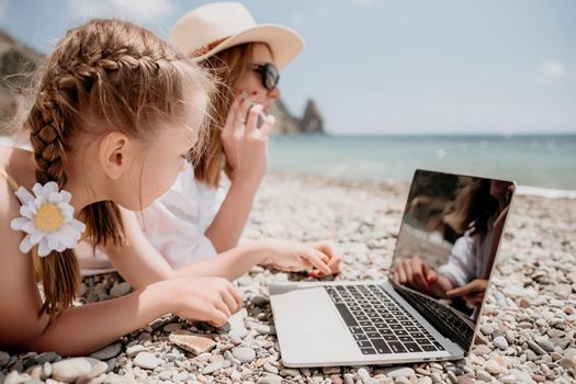 Woman sea laptop. Business woman in yellow hat working on laptop by sea. Close up on hands of pretty lady typing on computer outdoors summer day. Freelance, digital nomad, travel and holidays concept.