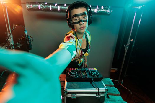 Disc jockey using turntables to mix music, performing techno beats and remix at electronic mixer. Artist creating record on vinyl with stereo instrument and audio equipment, night club production.
