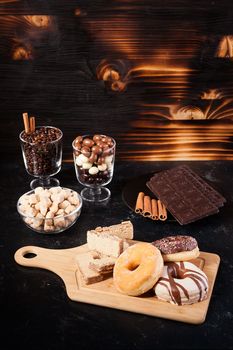 Unhealthy but delicous sweets and pastry on dark wooden background in studio photo