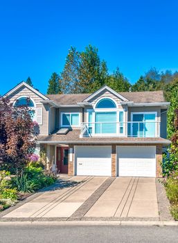 Big residential house with double garage and concrete drive way in front in suburban of Vancouver