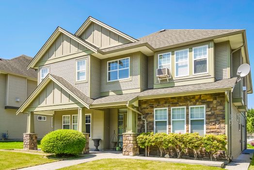 A perfect neighborhood. Luxury residential house with concrete pathway over front yard. Residential house with decorative bush at the entrance