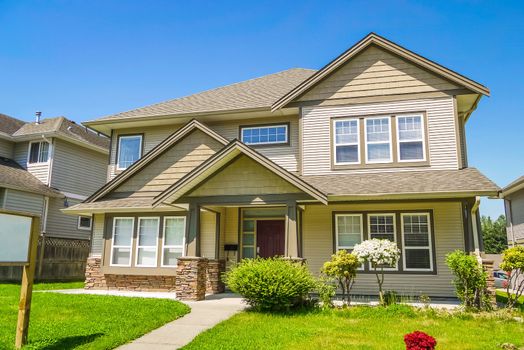 A perfect neighborhood. Family house with concrete pathway over the front yard. Residential house with decorative bush at the entrance