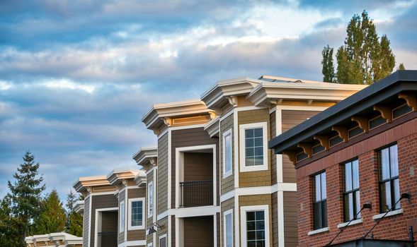 Top of residential building on cloudy sky background.