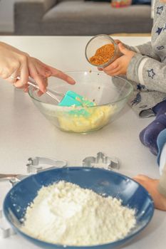 glass jar with brown sugar and a spoon in the background the hands of a woman preparing a cake