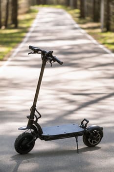 Black Electric scooter standing on the running board on the street.