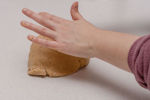 glass jar with brown sugar and a spoon in the background the hands of a woman preparing a cake