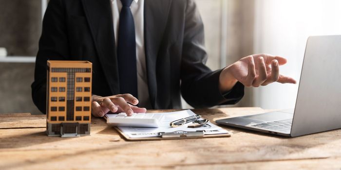 Entrepreneurs, business owners, accountants, real estate agents, A young man using a calculator to calculate his home budget to assess the risks of investing in real estate...